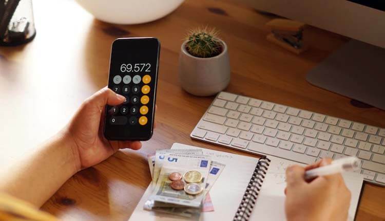Man using calculator to manage money consumption